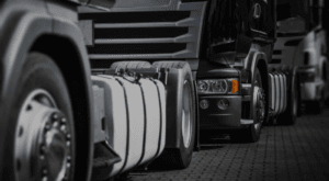 Row of trucks driving towards camera with close up view of tyres and rims.